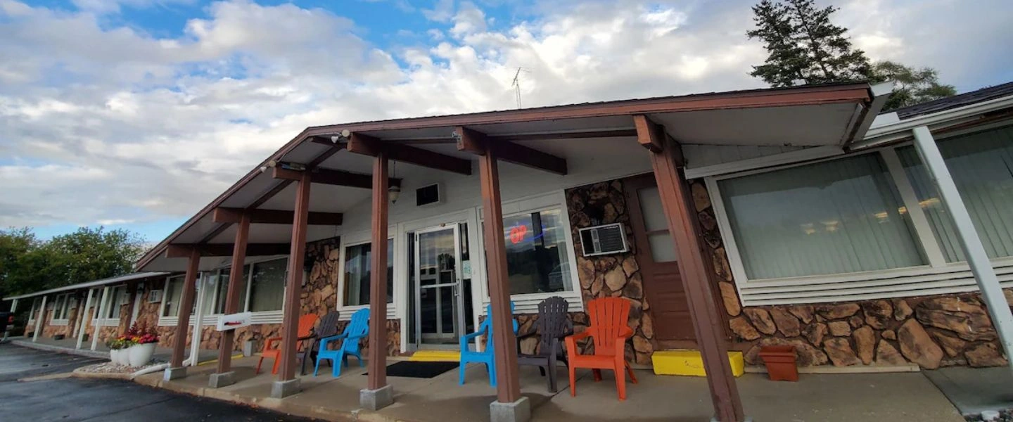 Stone and timber walkway of The Crossroads Motel beneath a wide evening sky